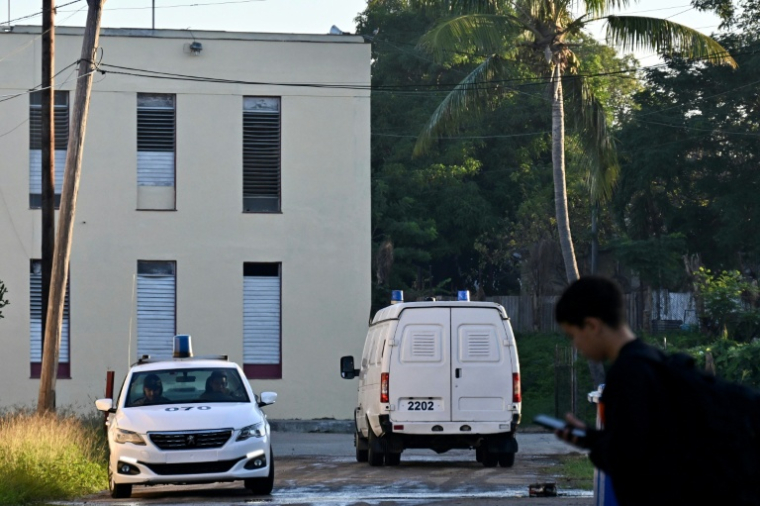 Une voiture de police surveille l’entrée à côté d’un fourgon de police devant le Tribunal municipal populaire de Marianao, à La Havane, le 26 novembre 2025, où se déroule le procès de l’ancien ministre cubain de l'Économie, Alejandro Gil ( AFP / YAMIL LAGE )