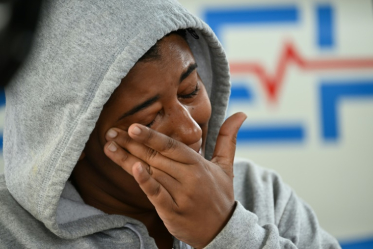Une femme pleure en attendant des nouvelles d'un proche à l'extérieur de la discothèque dont le toit s'est effondré deux jours auparavant, le 10 avril 2025 à Saint-Domingue, en République dominicaine ( AFP / MARTIN BERNETTI )