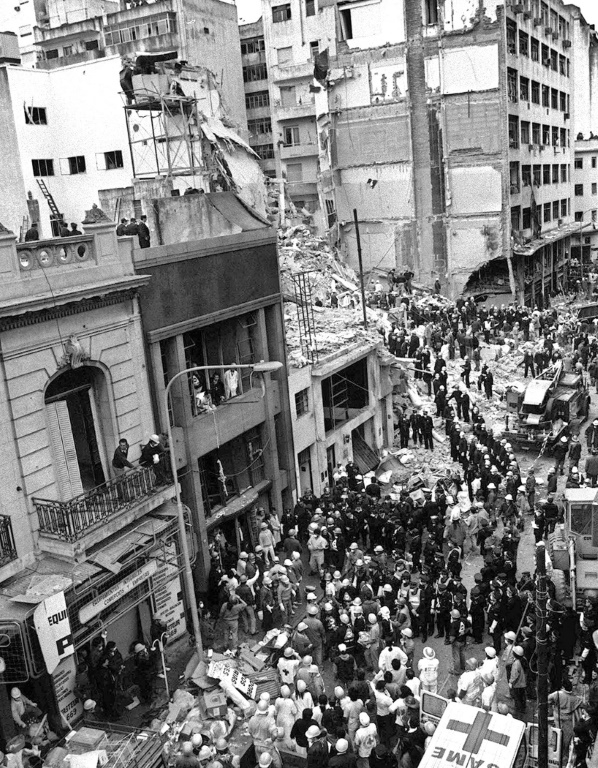 Des pompiers recherchent des blessés après l'explosion d'une bombe à la mutuelle juive Amia à Buenos Aires, le 18 juillet 1994 en Argentine ( AFP / Ali BURAFI )