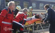 Photo diffusée par le Service ukrainien des situations d'urgence le 29 octobre 2026 montrant des secouristes ukrainiens transportant sur une civière une personne blessée après une attaque aérienne contre la gare de Dnipro, en Ukraine ( UKRAINIAN EMERGENCY SERVICE / Handout )
