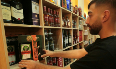 Un commerçant dispose des bouteilles d'alcool dans sa boutique de Qamichli, ville kurde du  nord-est de la Syrie, le 18 août 2026 ( AFP / Delil SOULEIMAN )