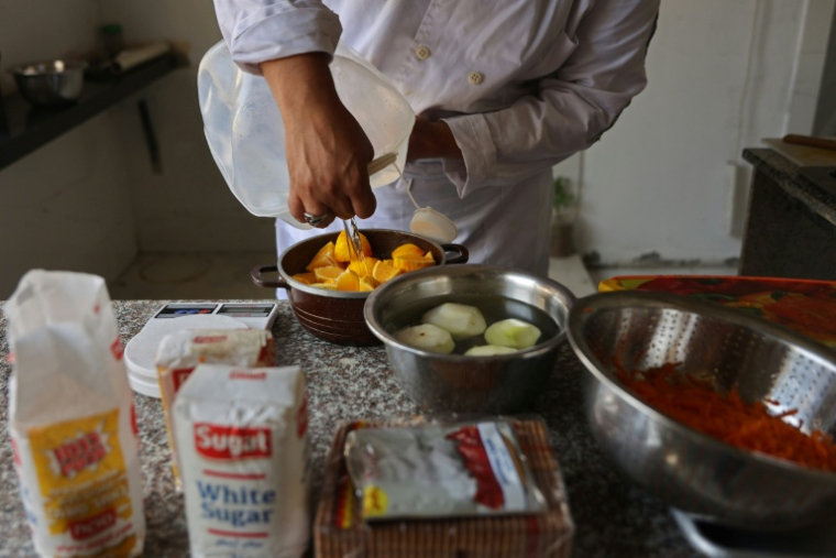 Des jeunes Palestiniens apprennent les bases de la cuisine à la Smile Kitchen Academy, dans le quartier de Rimal à Gaza, le 24 juin 2026 ( AFP / Omar AL-QATTAA )