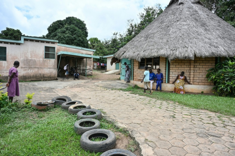 Des patients sont assis dans la cour d'un établissement offrant des soins à des déficiants intellectuels à Bouaké, en Côte d'Ivoire, le 17 septembre 2026 ( AFP / Issouf SANOGO )