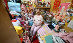 Lisa Lau assise sur son lit dans son logement d'un appartement subdivisé, le 30 avril 2026 à Hong Kong ( AFP / Peter PARKS )