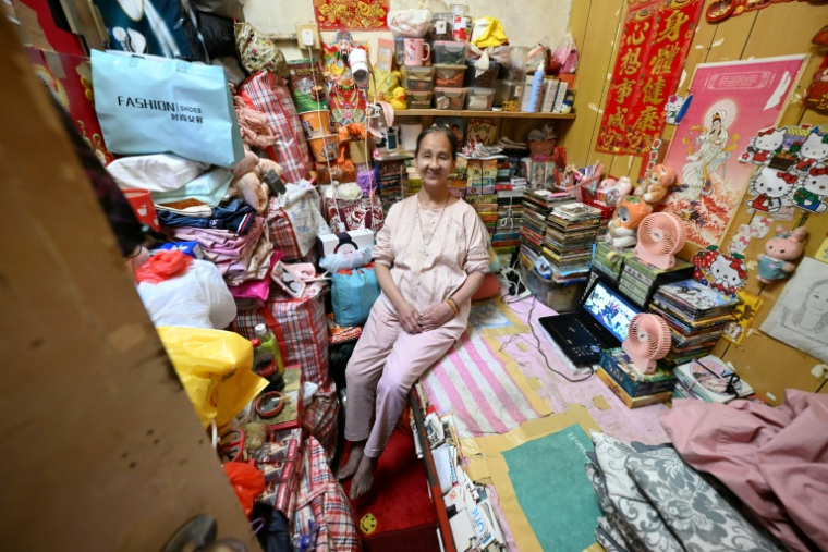 Lisa Lau assise sur son lit dans son logement d'un appartement subdivisé, le 30 avril 2026 à Hong Kong ( AFP / Peter PARKS )