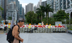Un homme passe devant des sacs de sable destinés à retenir les eaux de crue, alors que le super typhon Ragasa approche de Hong Kong, le 23 septembre 2025 ( AFP / Yan ZHAO )