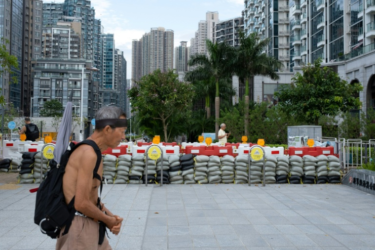Un homme passe devant des sacs de sable destinés à retenir les eaux de crue, alors que le super typhon Ragasa approche de Hong Kong, le 23 septembre 2025 ( AFP / Yan ZHAO )
