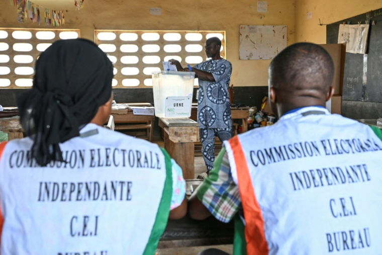 Des représentants de la commission électorale supervisent les opérations de vote pour la présidentielle ivoirienne, à Agboville le 25 octobre 2025 ( AFP / Issouf SANOGO )