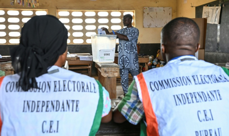 Des représentants de la commission électorale supervisent les opérations de vote pour la présidentielle ivoirienne, à Agboville le 25 octobre 2025 ( AFP / Issouf SANOGO )