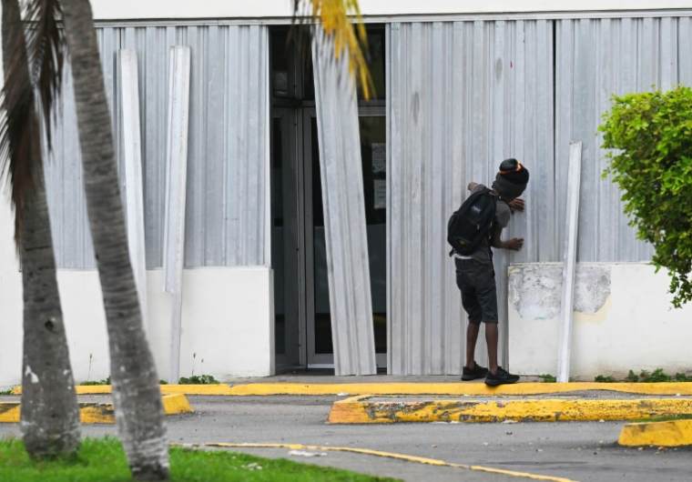 Installation de volets anti-tempête dans une entreprise avant l'arrivée de l'ouragan Melissa à Portmore, en Jamaïque, le 25 octobre 2025 ( AFP / Ricardo Makyn )