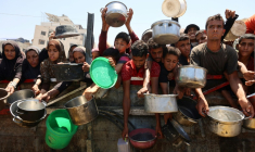 Des Palestiniens affamés attendent de recevoir une ration de soupe de lentilles lors d'une distribution alimentaire à Gaza, le 2 août 2025 ( AFP / Omar AL-QATTAA )