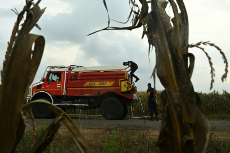 Des pompiers s'apprêtent à remplir leur citerne d'eau, le 16 août 2026 à Luglon, dans les Landes  ( AFP / Gaizka IROZ )