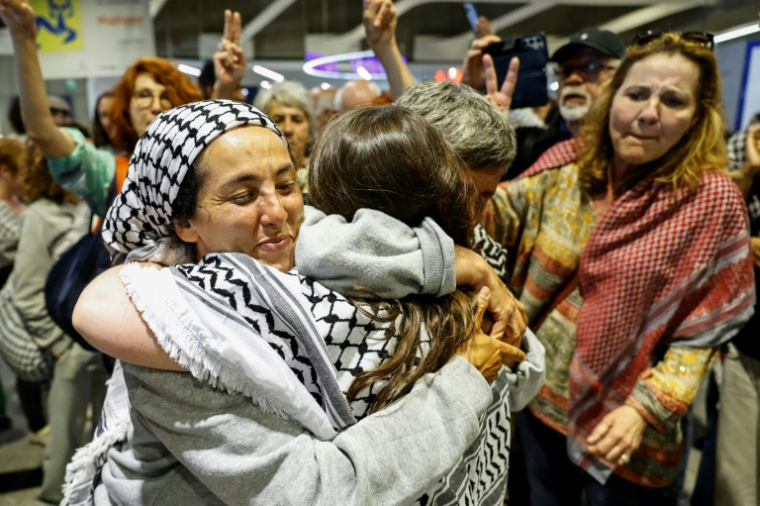 La militante française Meriem Hadjal (G), interpellée puis expulsée par Israël après l'interception de la flottille à destination de Gaza, embrasse un proche à son arrivée à l'aéroport de Roissy-Charles-de-Gaulle, près de Paris, le 22 mai 2026 ( AFP / SIMON WOHLFAHRT )