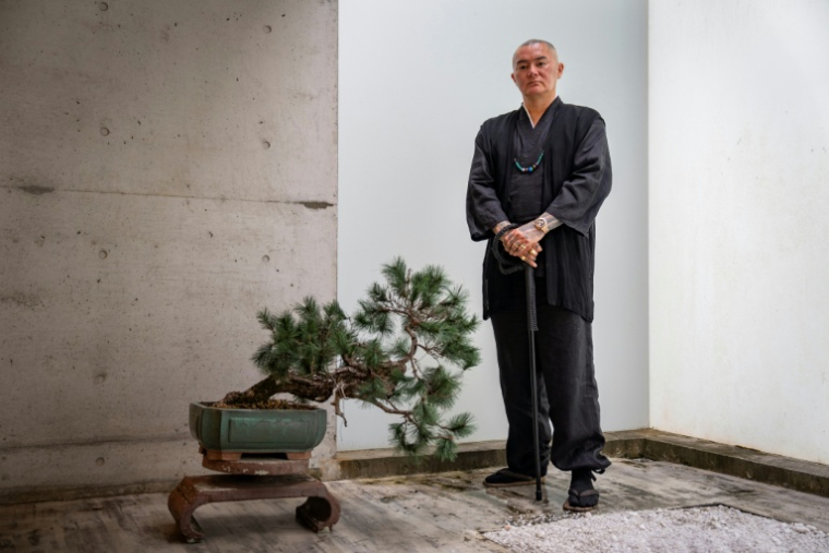 Remy, tatoueur professionnel, pose dans son studio à Ginowan, dans la préfecture d'Okinawa au Japon, le 19 mai 2026  ( AFP / Yuichi YAMAZAKI )