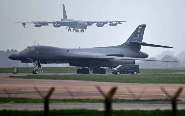 Un bombardier Boeing B-52 Stratofortress de l’US Air Force atterrit sur la piste, au-delà d’un bombardier Rockwell B-1 Lancer de l’US Air Force, sur la base de la RAF Fairford dans le sud-ouest de l’Angleterre, le 9 mars 2026 ( AFP / Henry NICHOLLS )