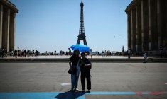 Des touristes se protègen du soleil au Trocadéro à Paris, le 18 juin 2026 ( AFP / Simon WOHLFAHRT )