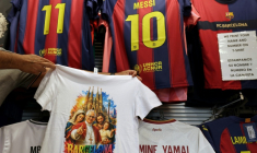 Un t-shirt orné d'une image du pape Léon XIV dans une boutique de souvenirs située à côté de la cathédrale de la Sagrada Familia, à la veille de sa visite à Barcelone le 7 juin 2026 ( AFP / LLUIS GENE )