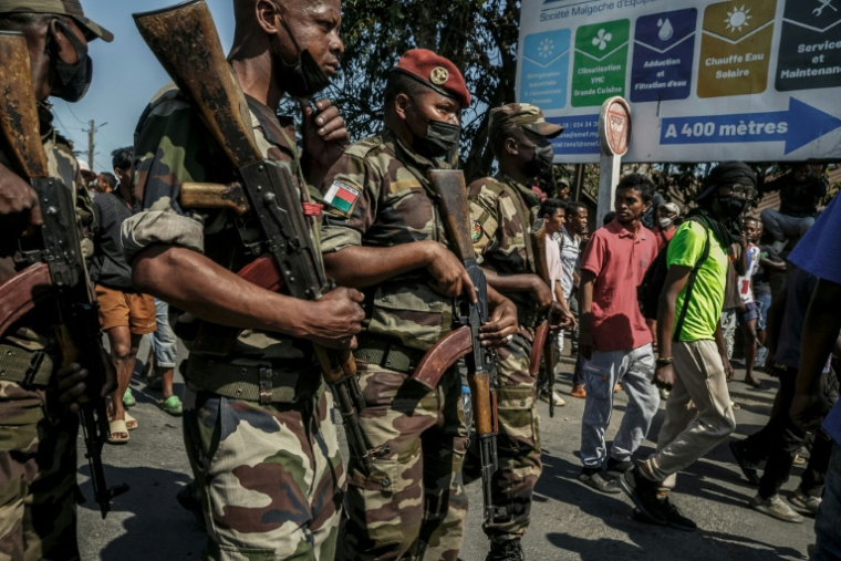 Des membres d'une unité de l'armée malgache se tiennent dans la rue près de leur camp situé près d'Antananarivo, le 11 octobre 2025 ( AFP / RIJASOLO )