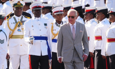 Le roi Charles III accueilli par une garde d'honneur de la police royale et de l'armée des Bahamas, à son arrivée à l'aéroport international Lynden Pindling, à Nassau, le 27 octobre 2026 ( POOL / Aaron Chown )