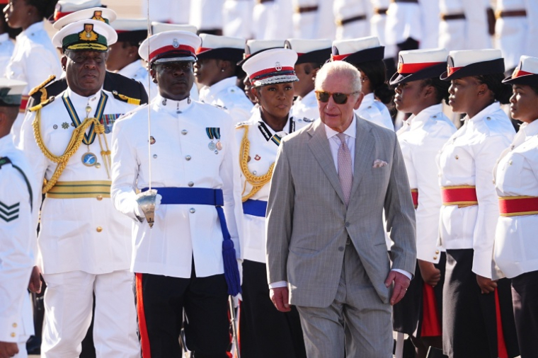 Le roi Charles III accueilli par une garde d'honneur de la police royale et de l'armée des Bahamas, à son arrivée à l'aéroport international Lynden Pindling, à Nassau, le 27 octobre 2026 ( POOL / Aaron Chown )