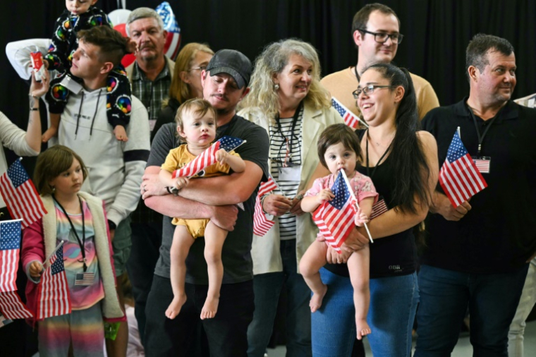 The first group of white Afrikaners to arrive in the United States for resettlement pose for photographers at Dulles Airport in Virginia ( AFP / SAUL LOEB )