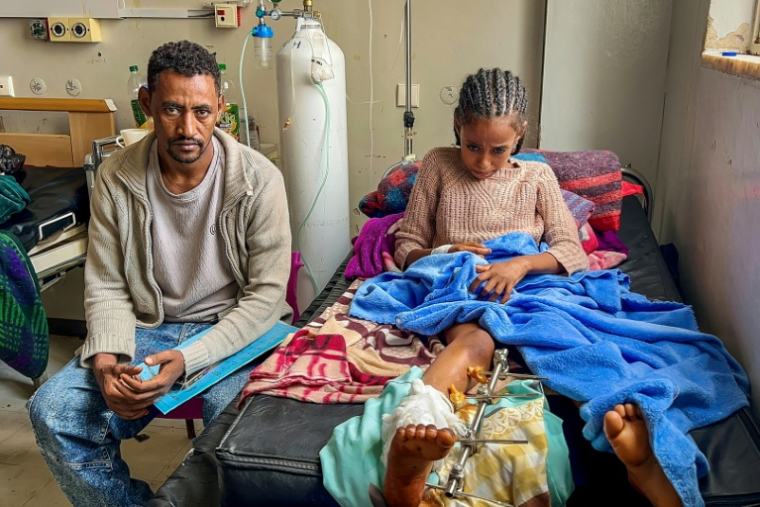 Betelhem, 10 ans, soigne sa jambe cassée, au côté de son père Haftom, le 6 octobre 2026, à l'hôpital Ayder de Mekele, capitale de l'Etat régional du Tigré, dans le nord de l'Ethiopie ( AFP / - )