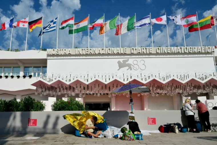 Des festivaliers campent sur le Lido devant le tapis rouge de la Mostra de Venise, en Italie, le 1er septembre 2026 ( AFP / Stefano RELLANDINI )