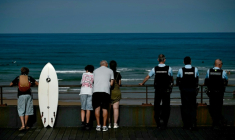 Des estivants et des gendarmes sur le front de mer à Lacanau, en Gironde, le 1er août 2026 ( AFP / Philippe Lopez )