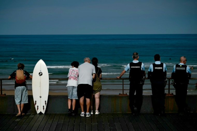 Des estivants et des gendarmes sur le front de mer à Lacanau, en Gironde, le 1er août 2026 ( AFP / Philippe Lopez )
