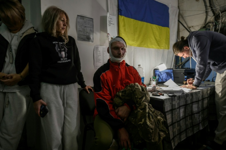 Un soldat ukrainien (C) blessé par un drone attend d'être soigné dans un centre de stabilisation, près de la ligne de front dans la région de Donetsk, dans l'est de l'Ukraine, le 10 octobre 2025 ( AFP / Ed JONES )