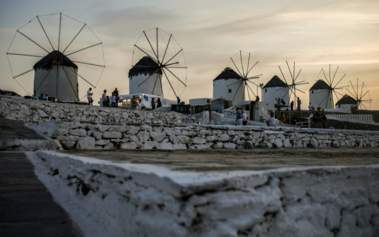 Les moulins à vent emblématiques de l'île grecque de Mykonos, au coucher du soleil à Chora, le 6 octobre 2020 ( AFP / David GANNON )