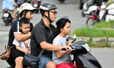 Une famille se déplace en motocyclette, le 4 juin 2025 à Hanoï ( AFP / Nhac NGUYEN )