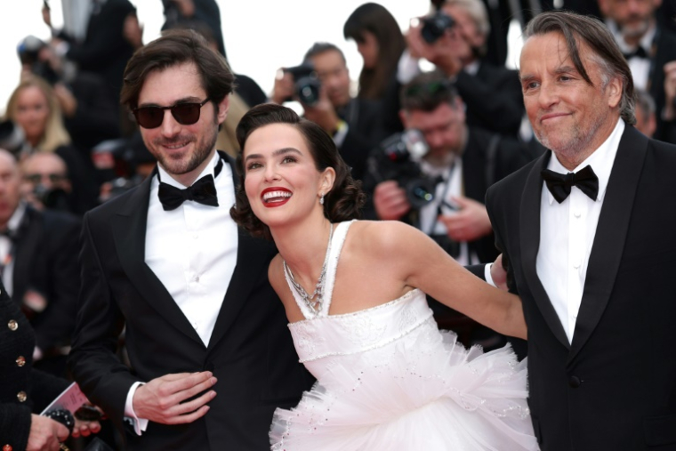 (g-d) L'acteur français Guillaume Marbeck, l'actrice américaine Zoey Deutch et le réalisateur américain Richard Linklater arrivent pour la projection du film "Nouvelle Vague" au 78e Festival de Cannes, le 17 mai 2025 ( AFP / Sameer AL-DOUMY )
