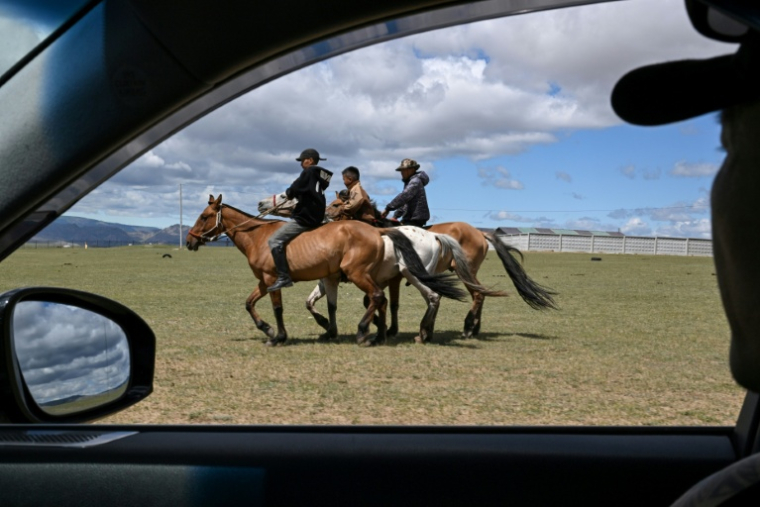 Hurts Gantumur (c), 6 ans, monte à cheval avec d'autres garçons avant le festival Naadam, le 23 juin 2026 à la périphérie d'Oulan-Bator, en Mongolie ( AFP / Adek BERRY )