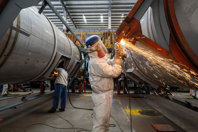 Des ouvriers travaillent sur une ligne de production fabriquant des conteneurs-citernes dans une usine de Nantong