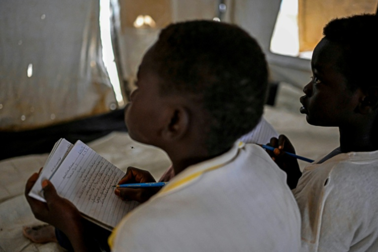 Des élèves suivent des cours dans une école primaire d'un camp de personnes déplacées près de Port-Soudan, gérée en partenariat avec l'Unicef, le 26 avril 2026 au Soudan ( AFP / Khaled DESOUKI )
