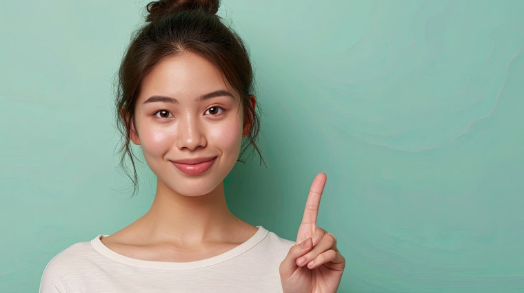 jeune femme montrant du doigt (Crédits: Adobe Stock)