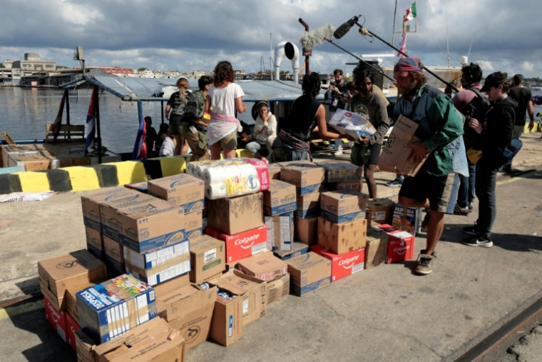 Des militants du convoi international "Nuestra America" en provenance du Mexique déchargent du bateau Marguro des colis d'aide humanitaire pour Cuba dans le port de La Havane, le 24 mars 2026 ( POOL / JORGE LUIS BANOS )
