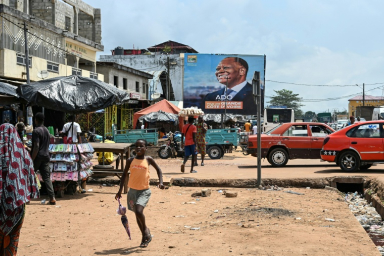 Une affiche de campagne du président ivoirien et candidat à la présidentielle du Rassemblement des houphouétistes pour la démocratie et la paix (RHDP) Alassane Ouattara, dans une rue de Dabou, à l'ouest d'Abidjan, le 16 octobre 2025 en Côte d'Ivoire ( AFP / Sia KAMBOU )