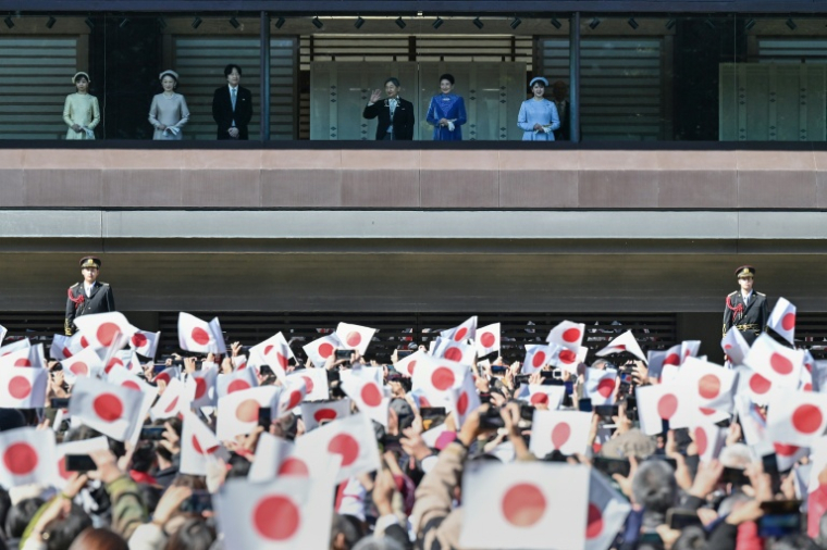 Des sympathisants agitent des drapeaux nationaux tandis que l'empereur Naruhito (3e à partir de la droite) apparaît au balcon du palais impérial avec l'impératrice Masako (2e à droite), leur fille la princesse Aiko (à droite), le prince héritier Akishino (3e à gauche), la princesse héritière Kiko (2e à gauche) et leur fille la princesse Kako (à gauche), à l'occasion du 65e anniversaire de l'empereur, à Tokyo, le 23 février 2025. ( AFP / Richard A. Brooks )