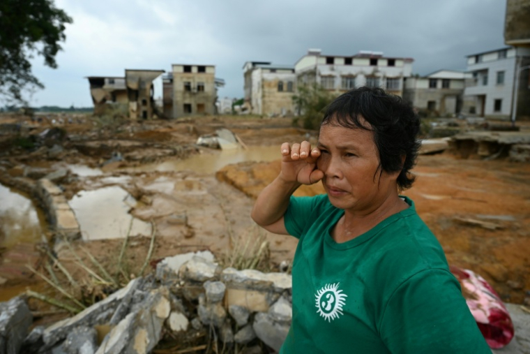 Une femme examine les dégâts dans le village de Liulan, inondé lorsqu'un réservoir s’est effondré dans la ville de Hengzhou, dans la région du Guangxi, au sud-ouest de la Chine, le 8 juillet 2026 ( AFP / GREG BAKER )