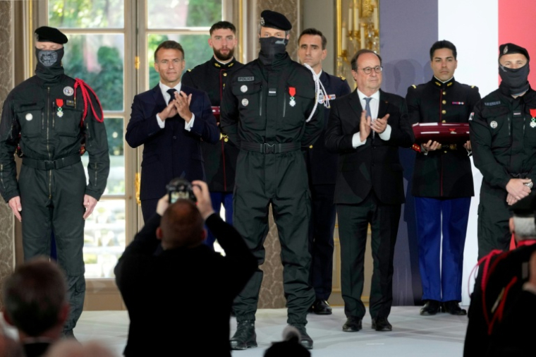 Le président Emmanuel Macron (2e g) et son prédécesseur François Hollande (2e d) assistent à une cérémonie en l'honneur des policiers intervenus au Bataclan pendant attentats du 13 novembre 2015, à l'Élysée, le 21 avril 2026 à Paris ( POOL / Michel Euler )