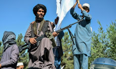 Un membre des forces de sécurité talibanes et d'autres personnes célèbrent le cinquième anniversaire de leur retour au pouvoir à Kaboul, le 15 août 2026 ( AFP / Wakil KOHSAR )