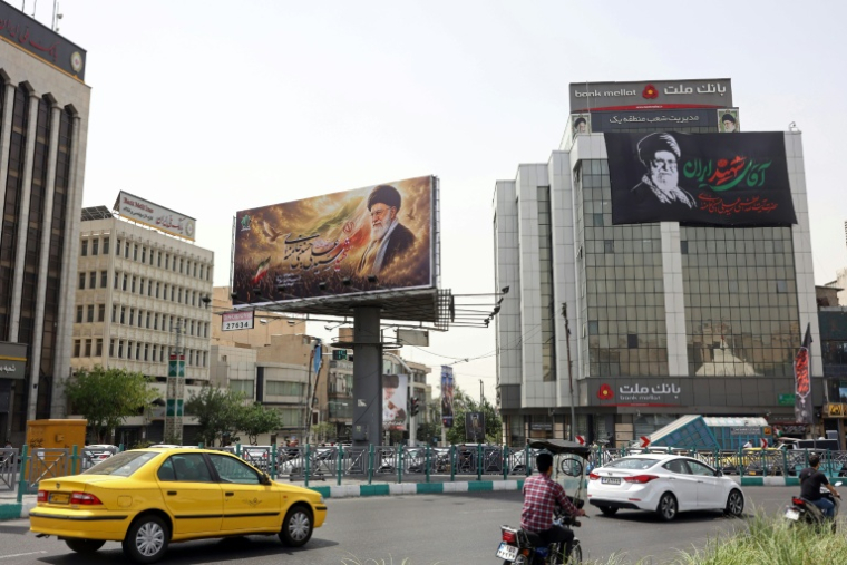Des automobilistes passent devant d'immenses panneaux publicitaires arborant des photos de l'ayatollah Ali Khamenei, le défunt guide suprême de l'Iran, le 2 juillet 2026 à Téhéran, à la veille de ses funérailles ( AFP / - )