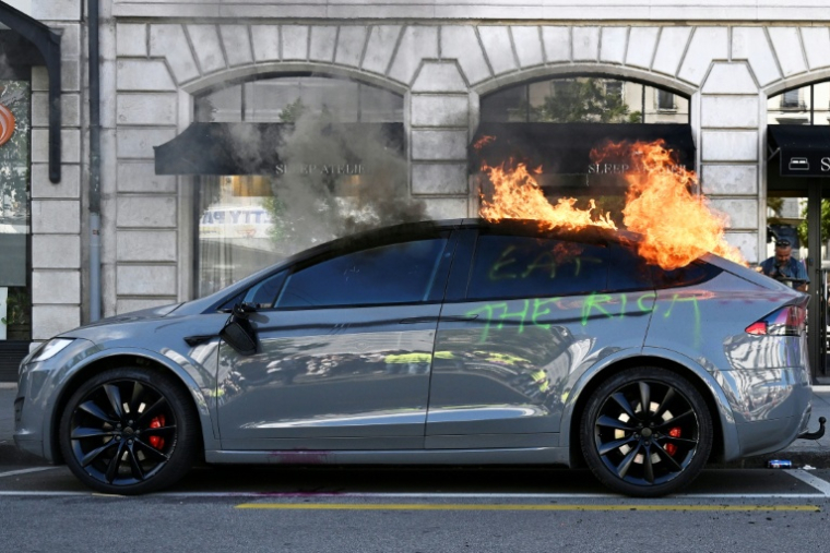 Une voiture Tesla incendiée lors d'une manifestation de la coalition "Non au G7", le 14 juin 2026 à Genève, en Suisse, à la veille du début du sommet du G7 à Evian, en France ( AFP / Gabriel Monnet )