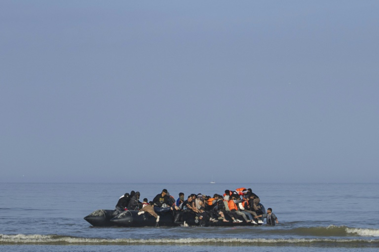 Des migrants tentent de monter à bord d'un bateau de passeurs pour traverser la Manche au large de la plage d'Equihen, dans le nord de la France, le 30 juin 2025 ( AFP / Sameer Al-DOUMY )