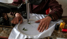 La couturière Rahima Alavi brode à la machine à coudre un tissu dans sa boutique à Bamiyan, le 26 janvier 2026 en Afghanistan ( AFP / Wakil KOHSAR )