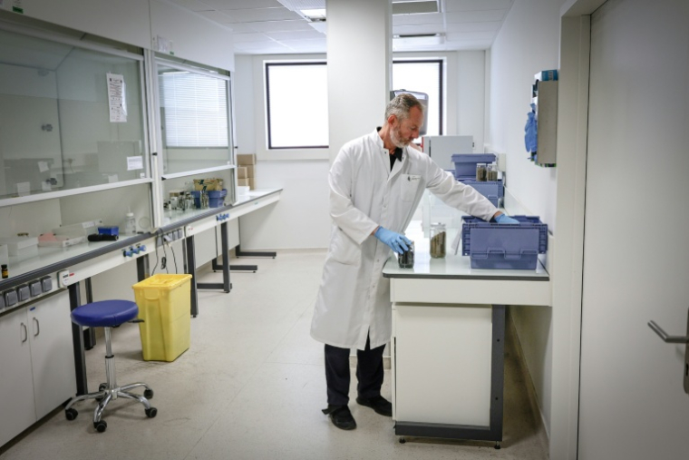 Le major de gendarmerie Christophe Briffa manipule des échantillons de bois brûlé à l'Institut de recherche criminelle de la gendarmerie nationale (IRCGN), à Cergy-Pontoise ( AFP / STEPHANE DE SAKUTIN )