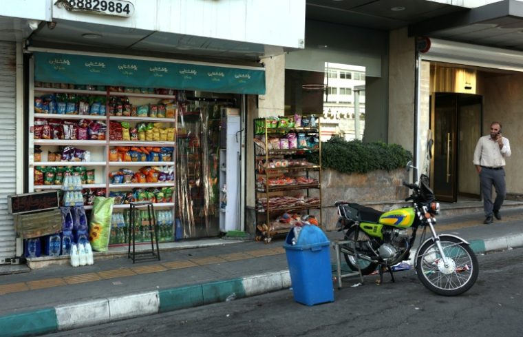 Un homme au téléphone marche dans les rues vides de Téhéran , le 23 juin 2025 ( AFP / ATTA KENARE )