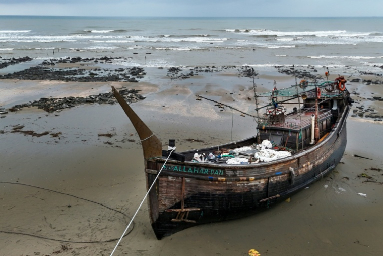 Un bateau de pêche, intercepté par les garde-côtes du Bangladesh (BCG) pour soupçon de trafic d'êtres humains, échoué sur le rivage à Cox's Bazar, le 21 juillet 2026 au Bangladesh ( AFP / Munir UZ ZAMAN )